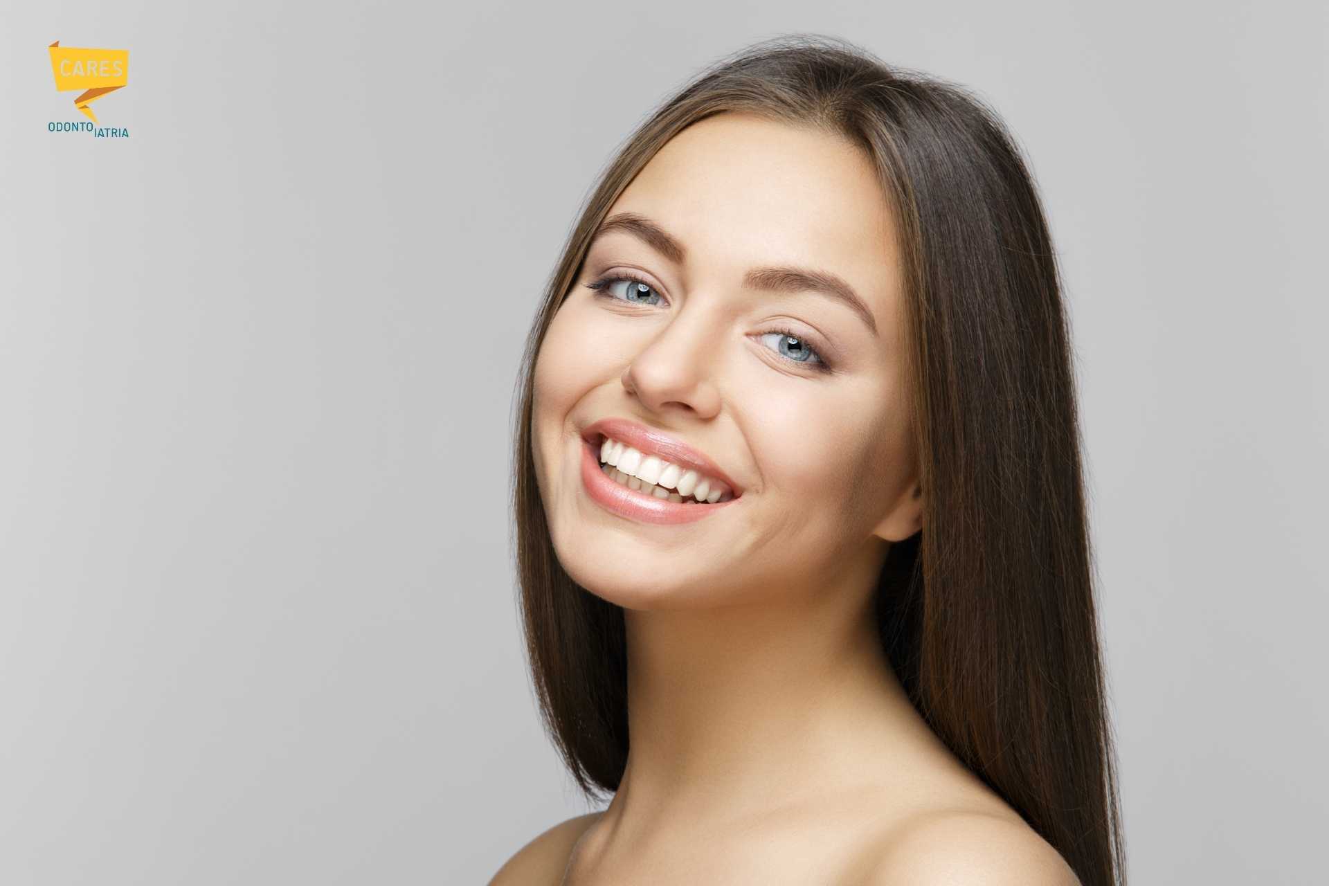Sorriso luminoso con confronto delle tonalità dei denti durante trattamento di sbiancamento presso Cares Odontoiatria Uta, vicino a Villaspeciosa.