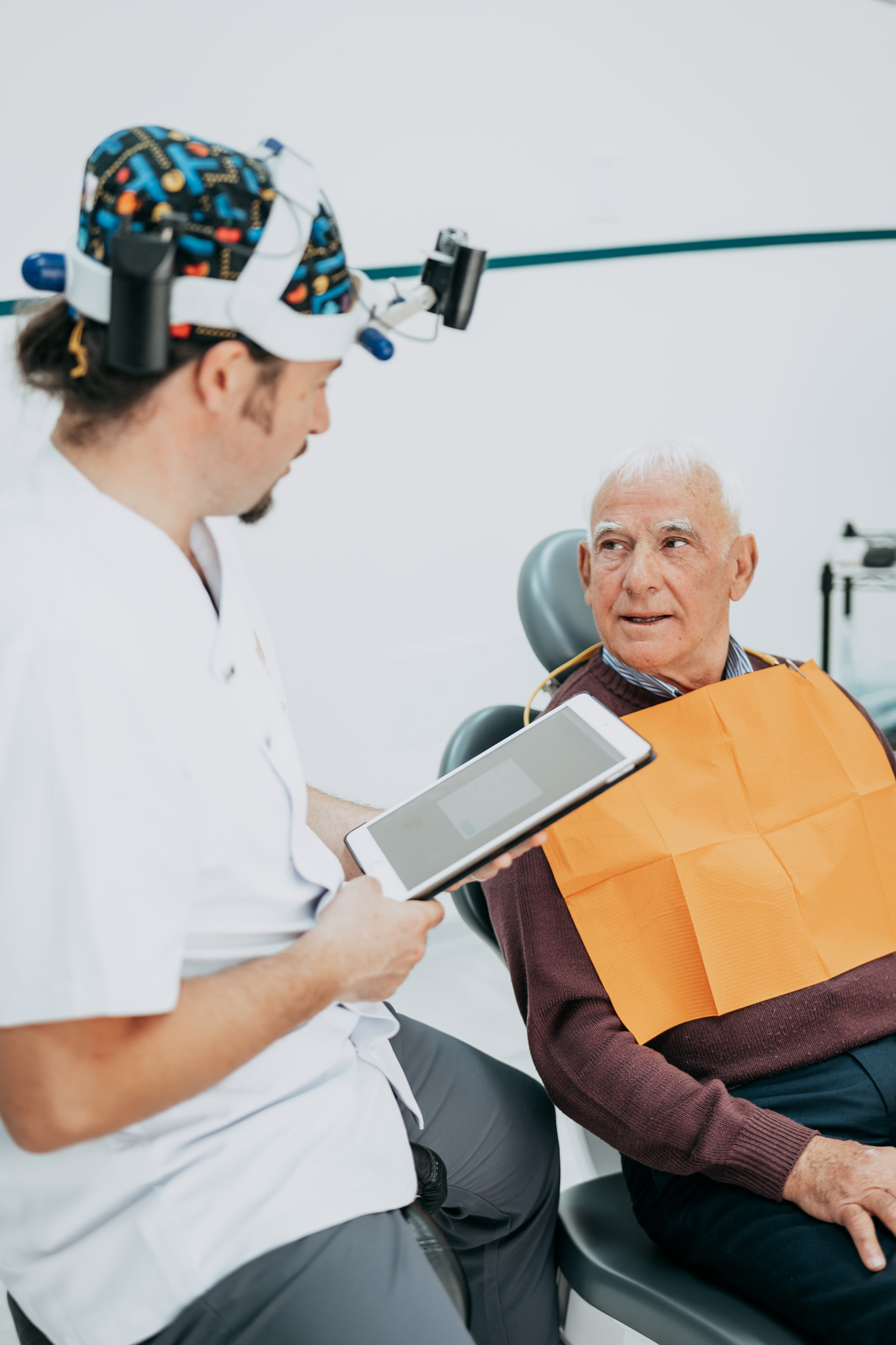 Dentista di Cares Odontoiatria Uta che spiega un trattamento a un paziente, vicino a Decimomannu.