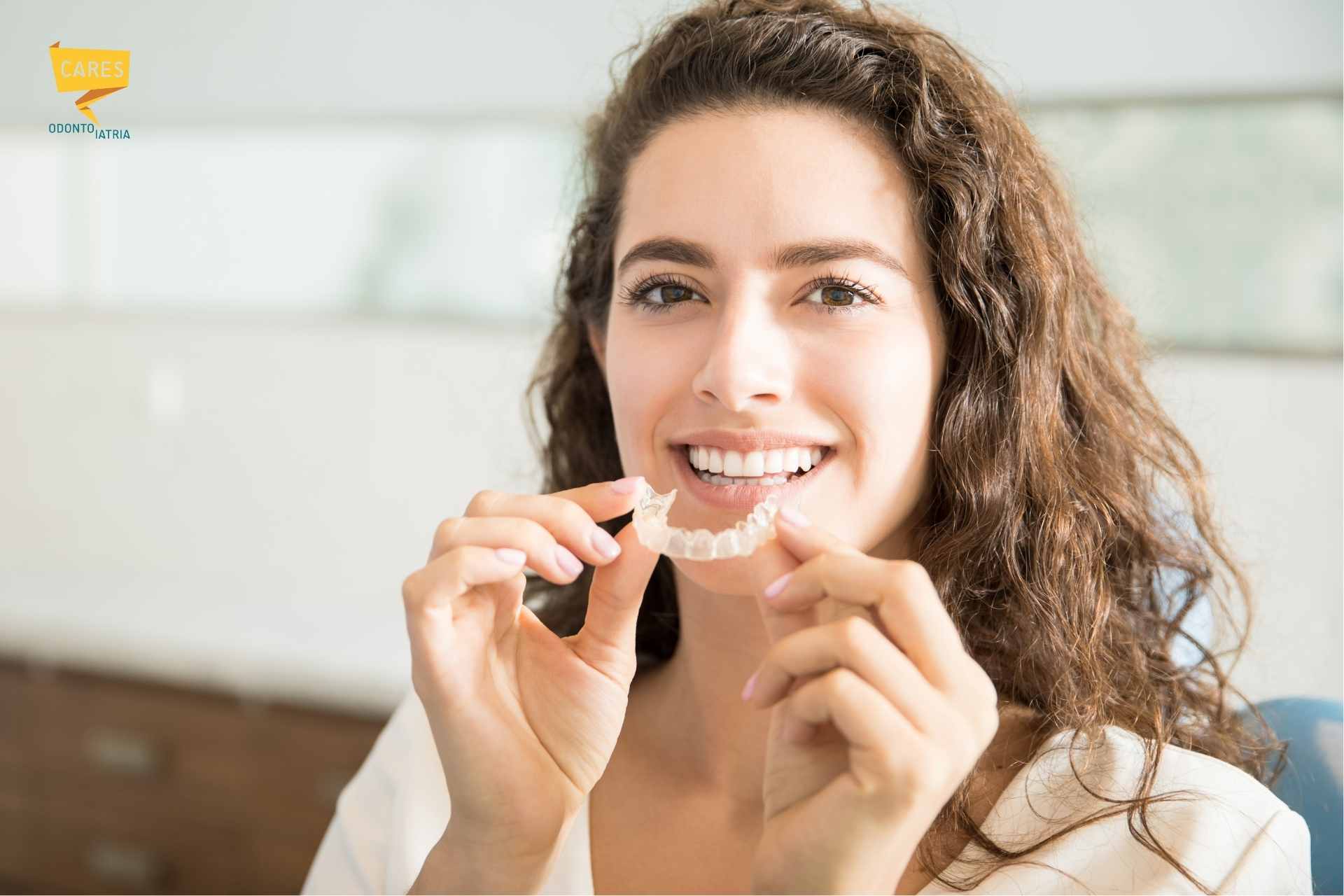 Donna sorridente con allineatore trasparente, trattamento ortodontico presso Cares Odontoiatria Uta vicino a Decimomannu