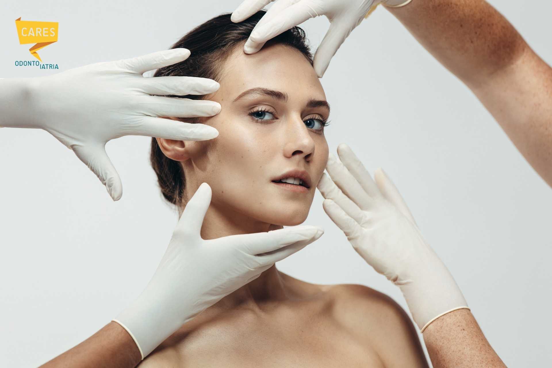 Mani con guanti bianchi che incorniciano il viso di una donna, simbolo di medicina estetica e cura dell’armonia del volto