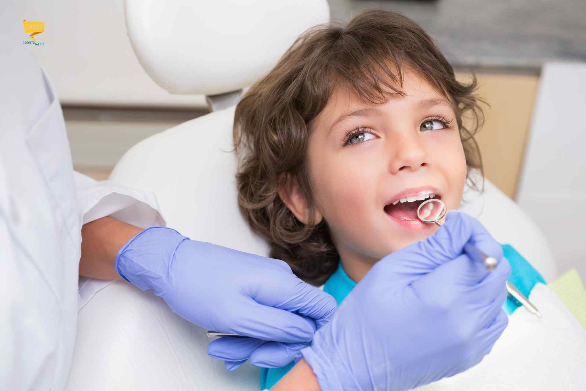 Carie sui denti da latte: visita dal dentista pediatrico Bambino durante una visita dal dentista pediatrico per la cura della carie sui denti da latte