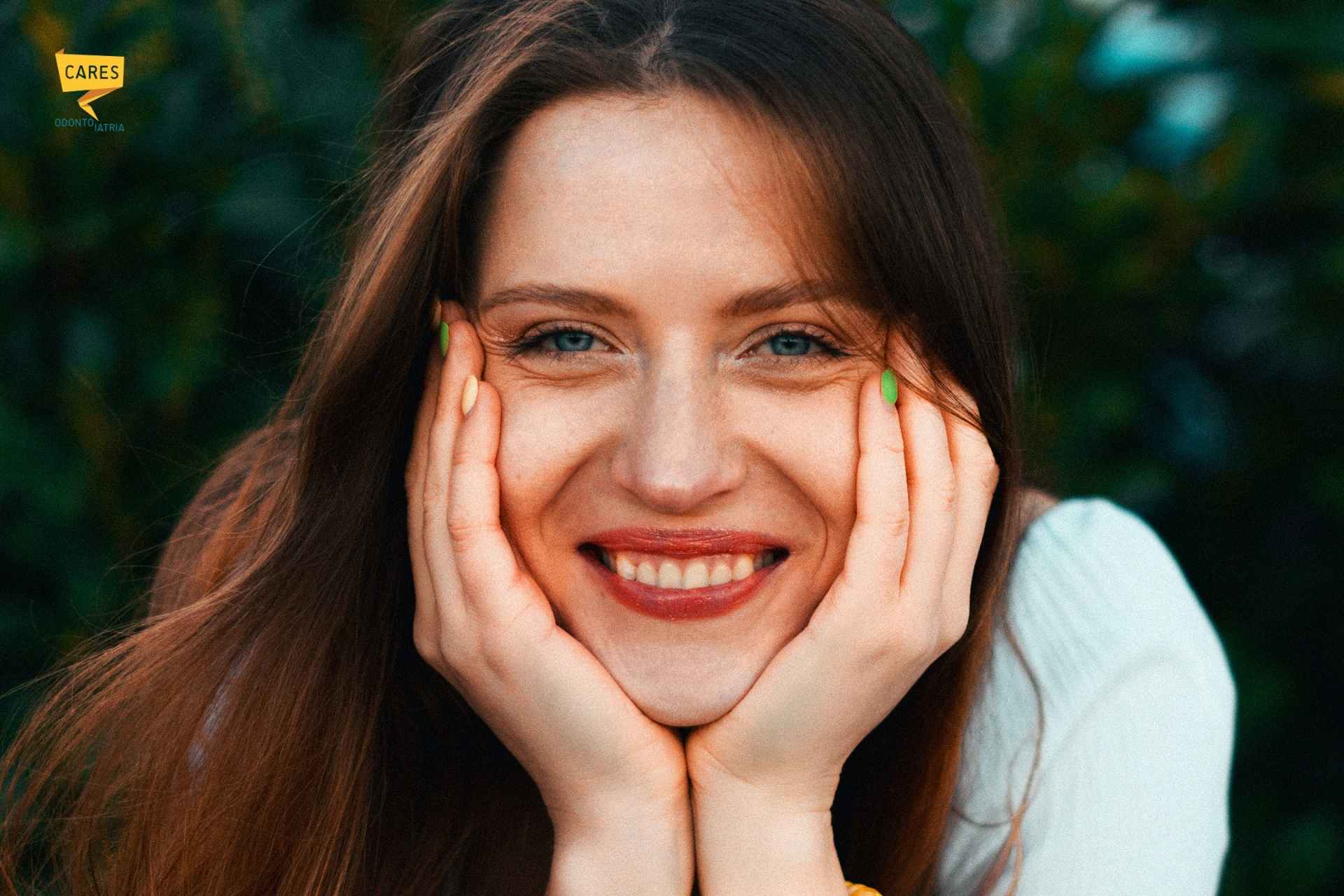 Donna che sorride mostrando le gengive, esempio di gummy smile in un contesto naturale.