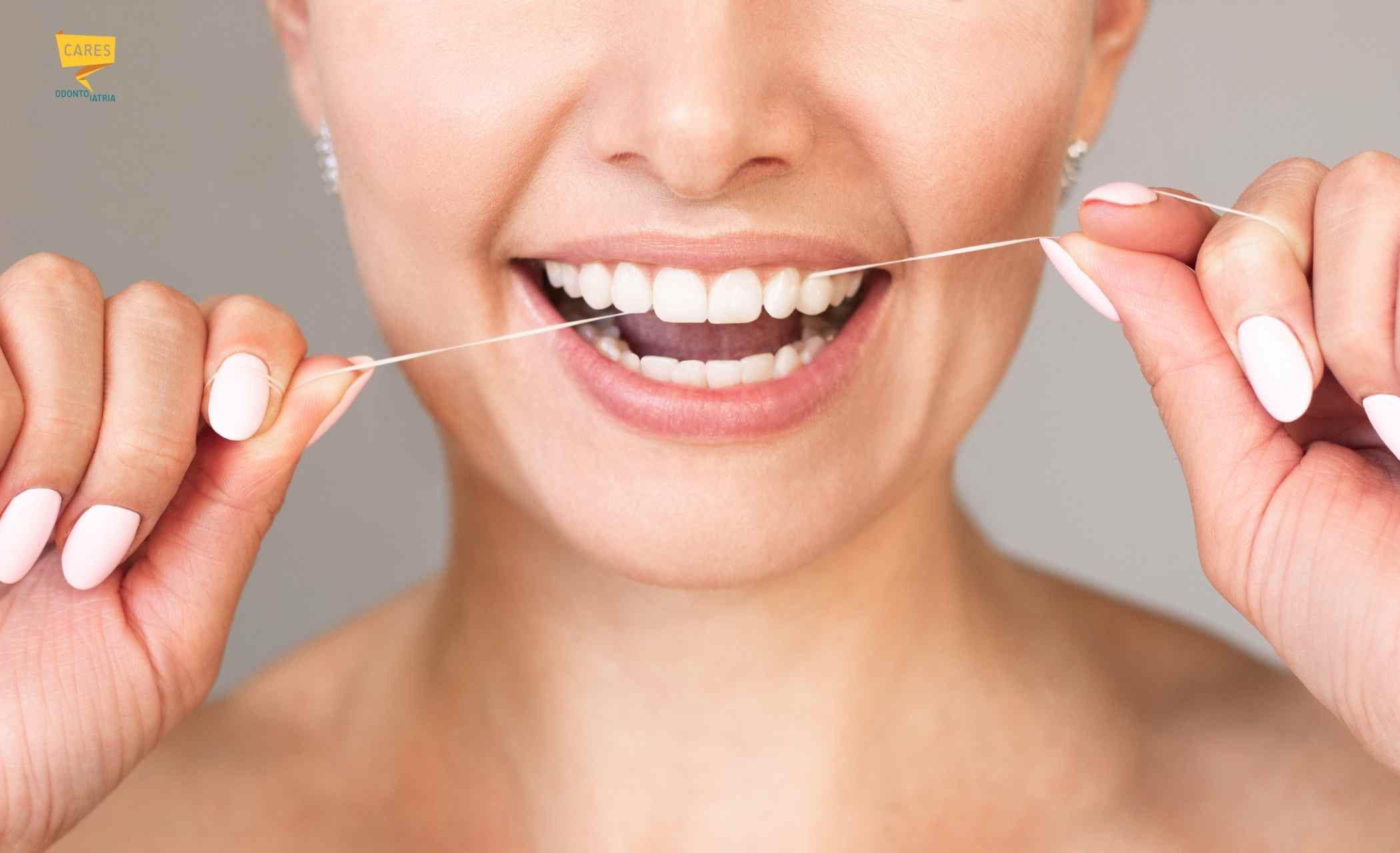 Filo interdentale: come si usa correttamente per l’igiene orale Donna che utilizza il filo interdentale per rimuovere placca e batteri tra i denti e migliorare l’igiene orale