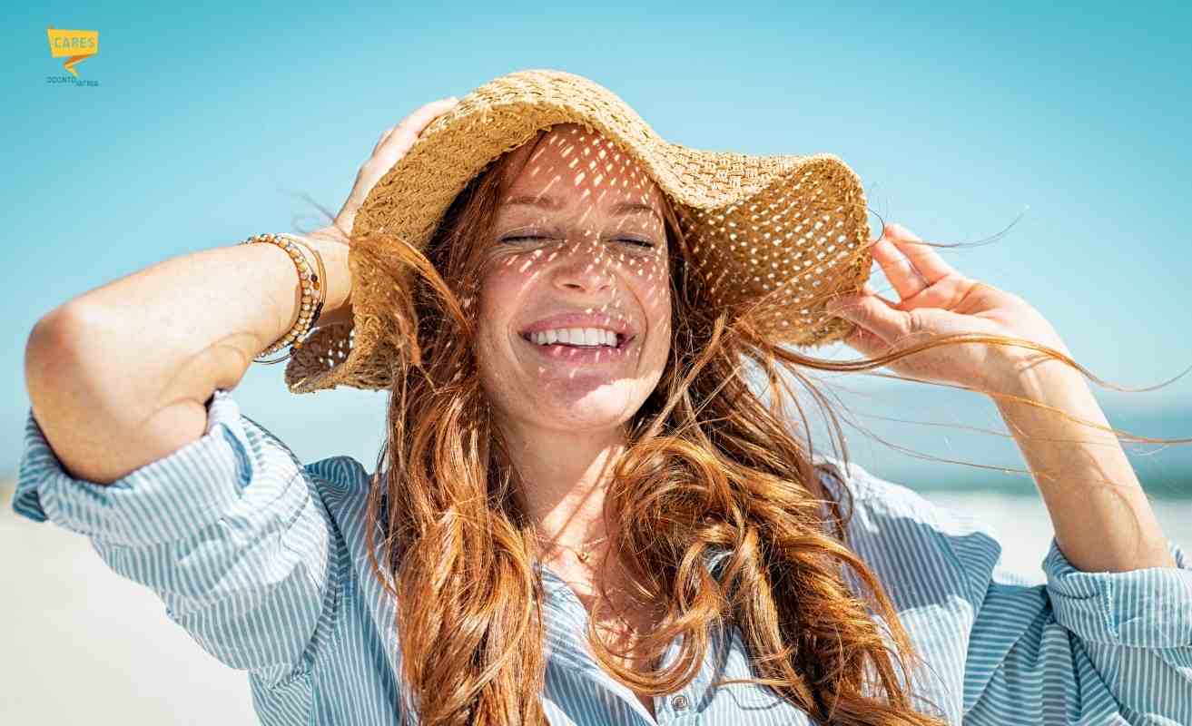 Donna sorridente al mare con denti bianchi dopo sbiancamento denti professionale
