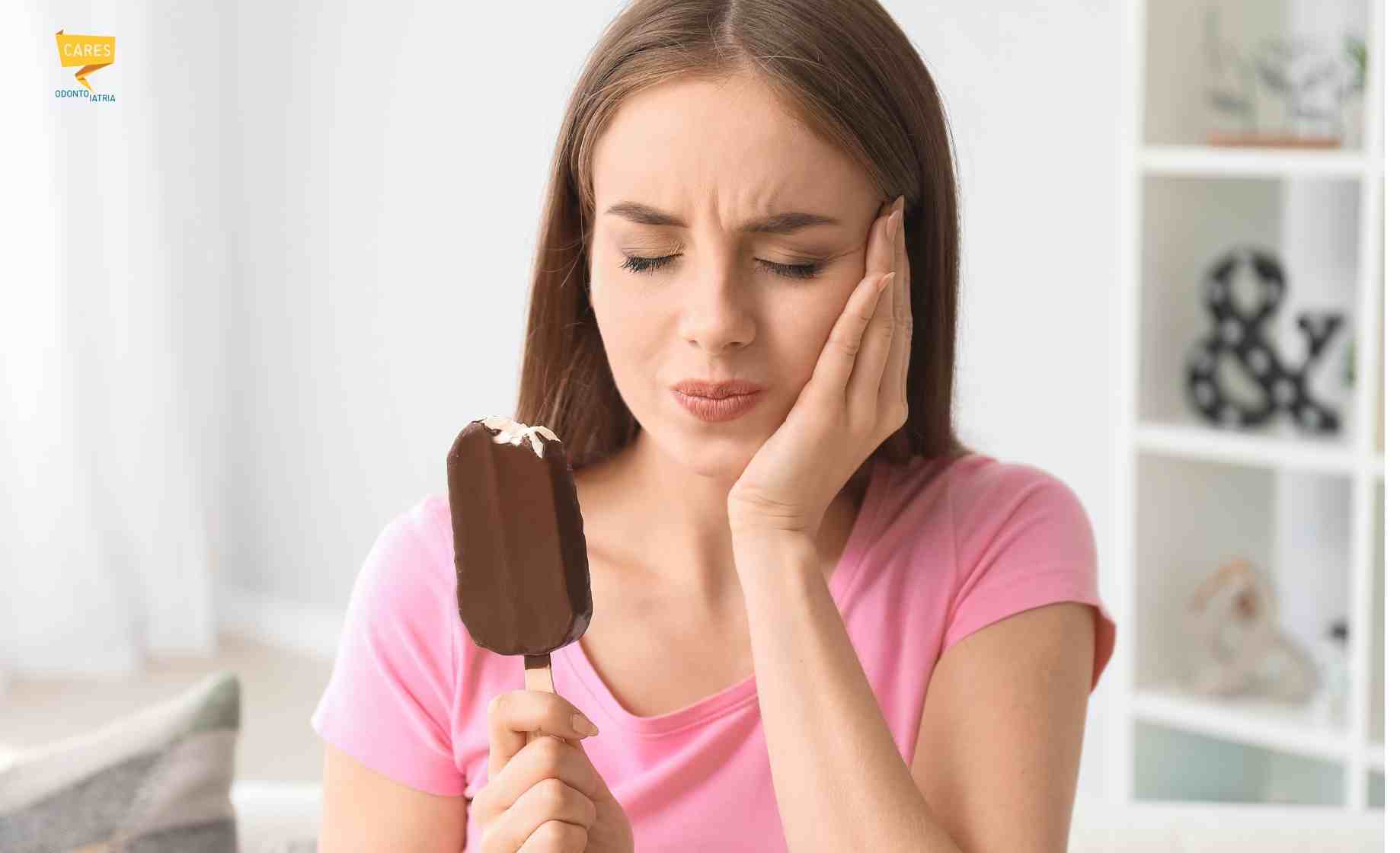 Donna con denti sensibili al freddo prova dolore mentre mangia un gelato