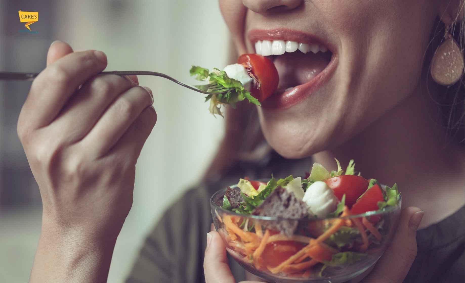 Donna mangia un’insalata nell’ambito di un’alimentazione sana per denti sani e prevenzione della carie