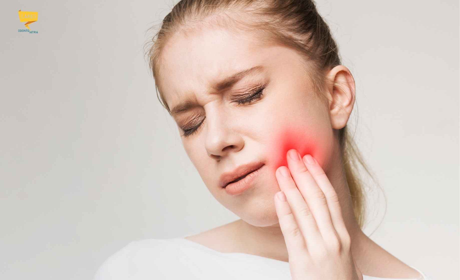 Donna con dolore alla guancia nella zona del dente del giudizio, possibile sintomo di pericoronite