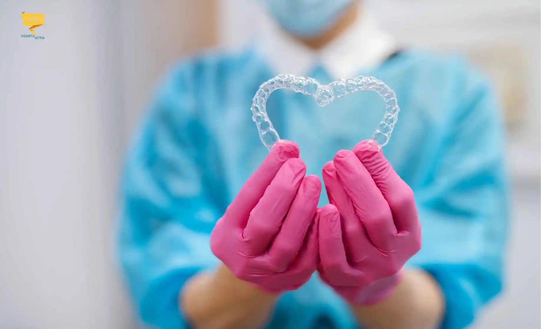 Ortodontista Cagliari: professionista di CARES Odontoiatria mostra un allineatore dentale trasparente per correggere i denti storti.